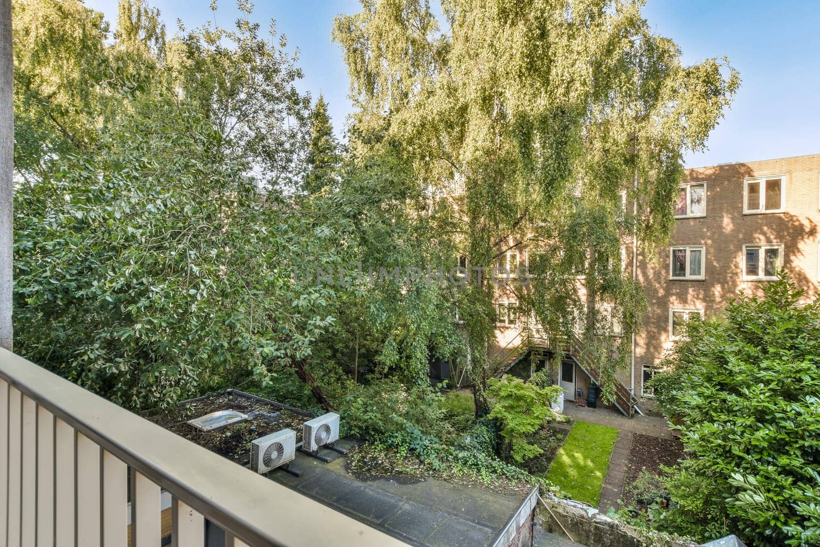 the view of a backyard from a balcony with trees by casamedia