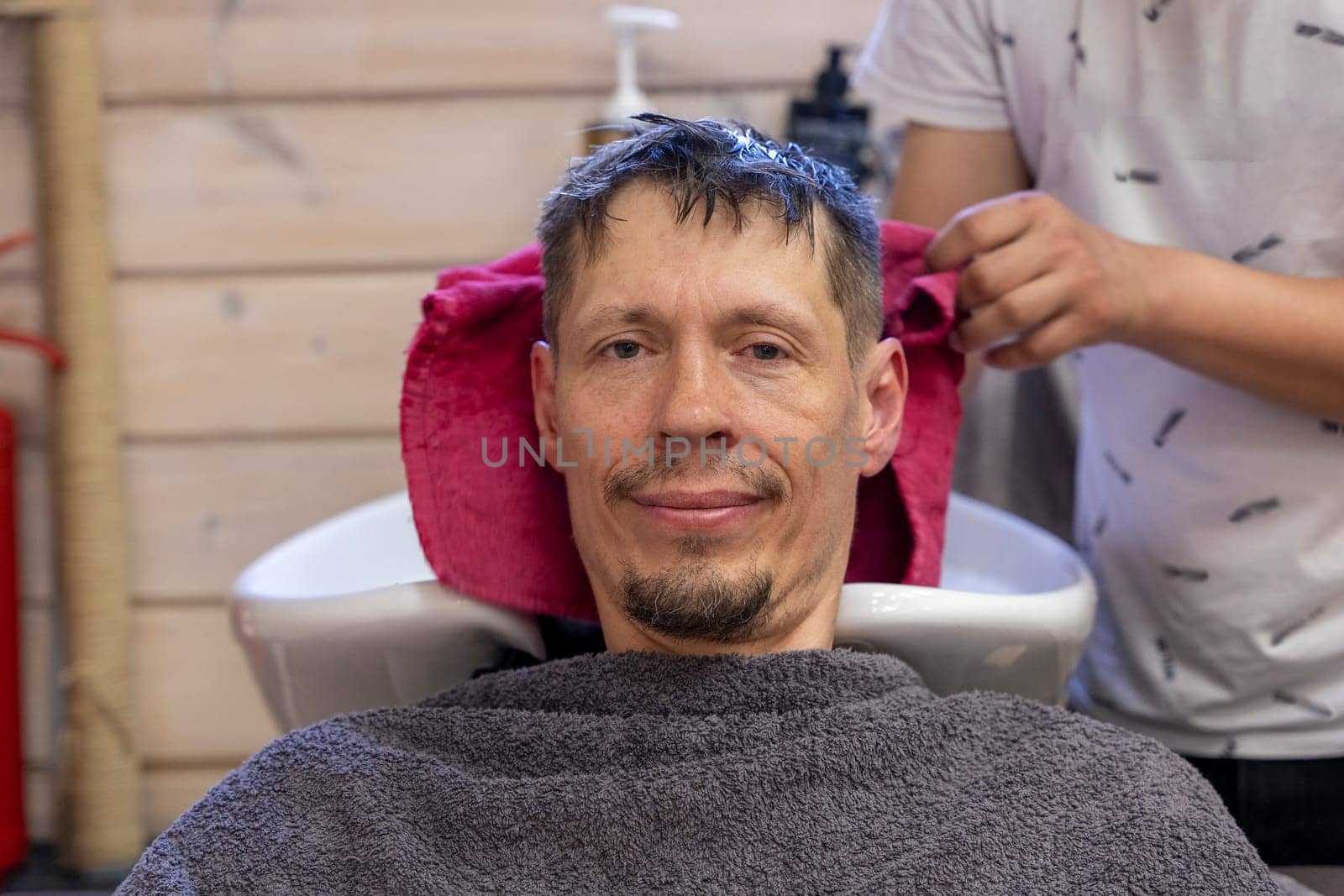 a man washes his hair while visiting a hairdresser. a hairdresser washes a client's hair before a haircut in a beauty salon. Men's haircut in a barbershop.