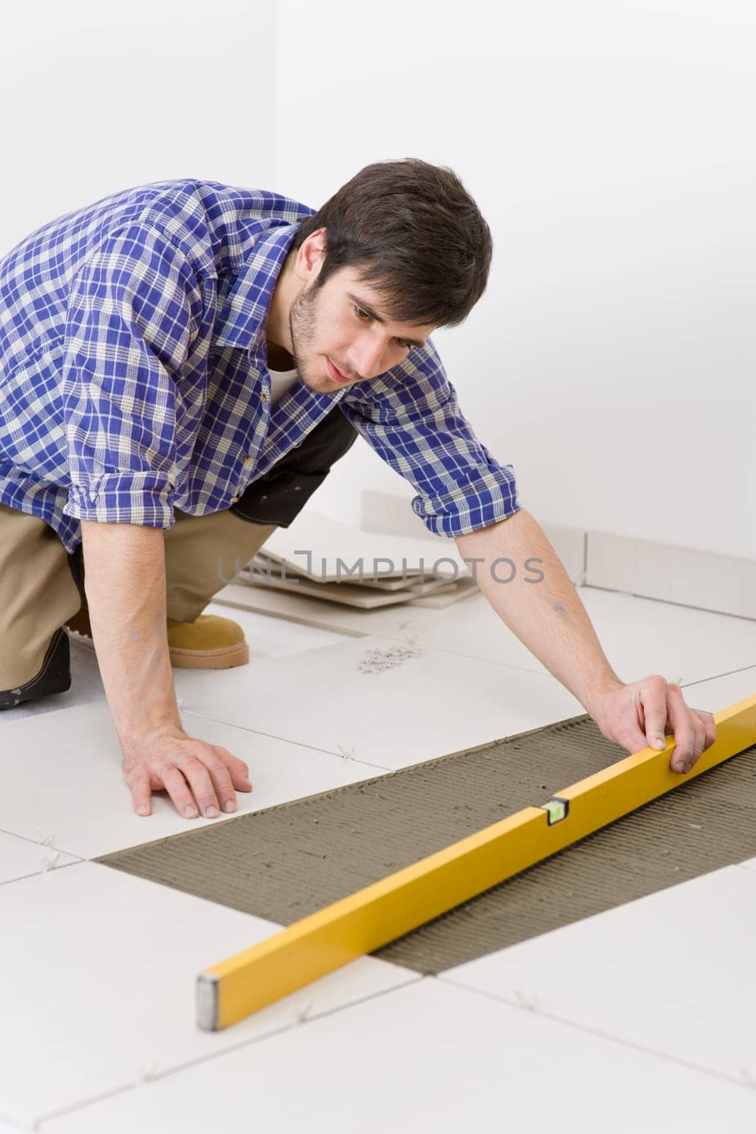 Home tile improvement - handyman with level