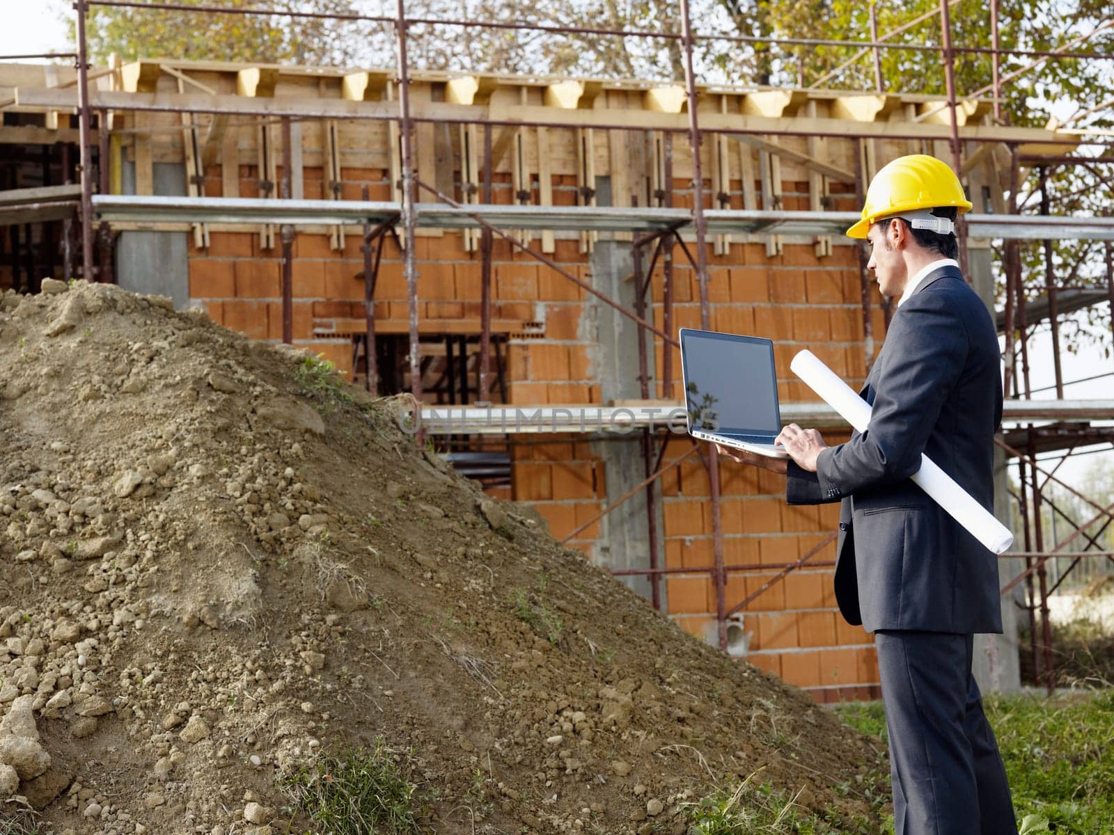 architect with pc in construction site