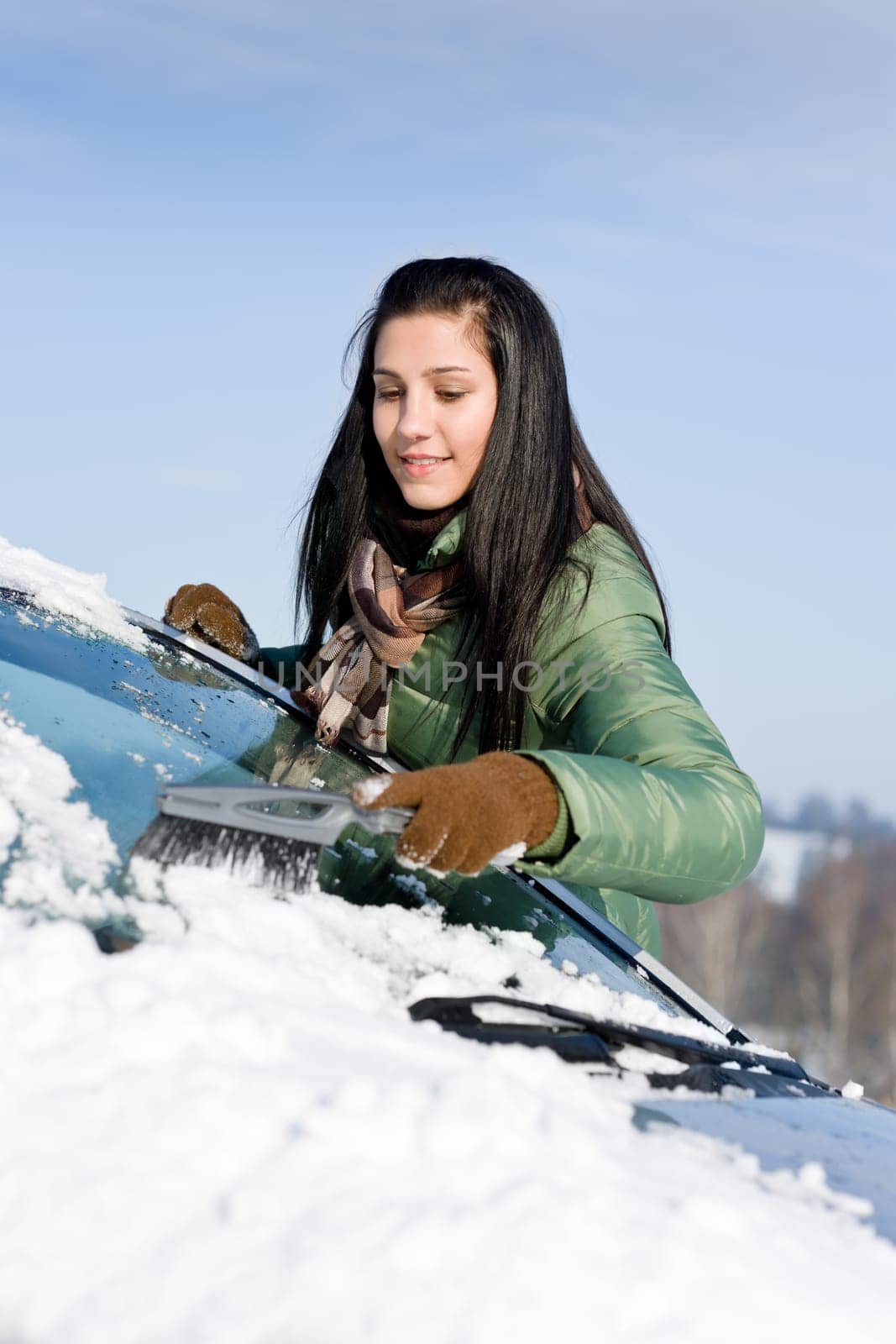 Winter car - woman remove snow from windshield