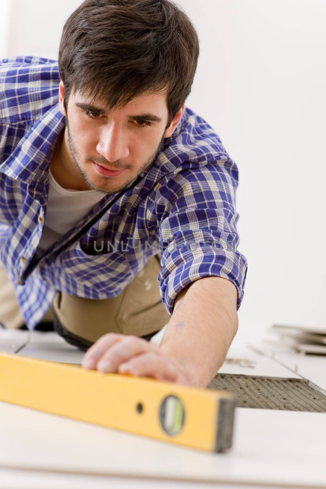 Home tile improvement - handyman with level