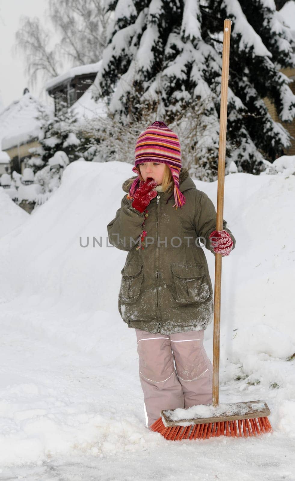 Little girl sweeping snow