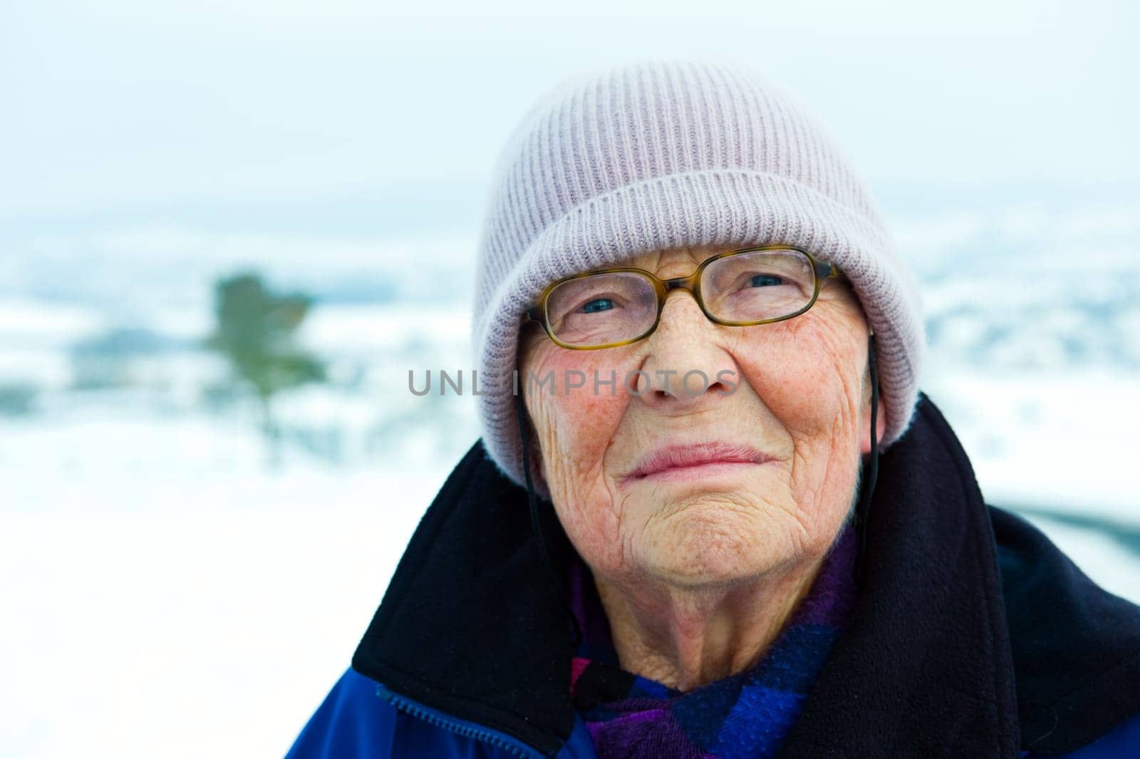 old woman in front of winter landscape