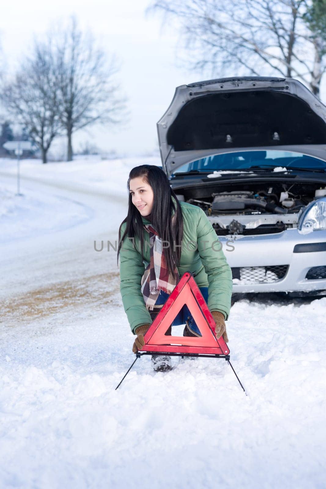 Winter car breakdown - woman warning triangle