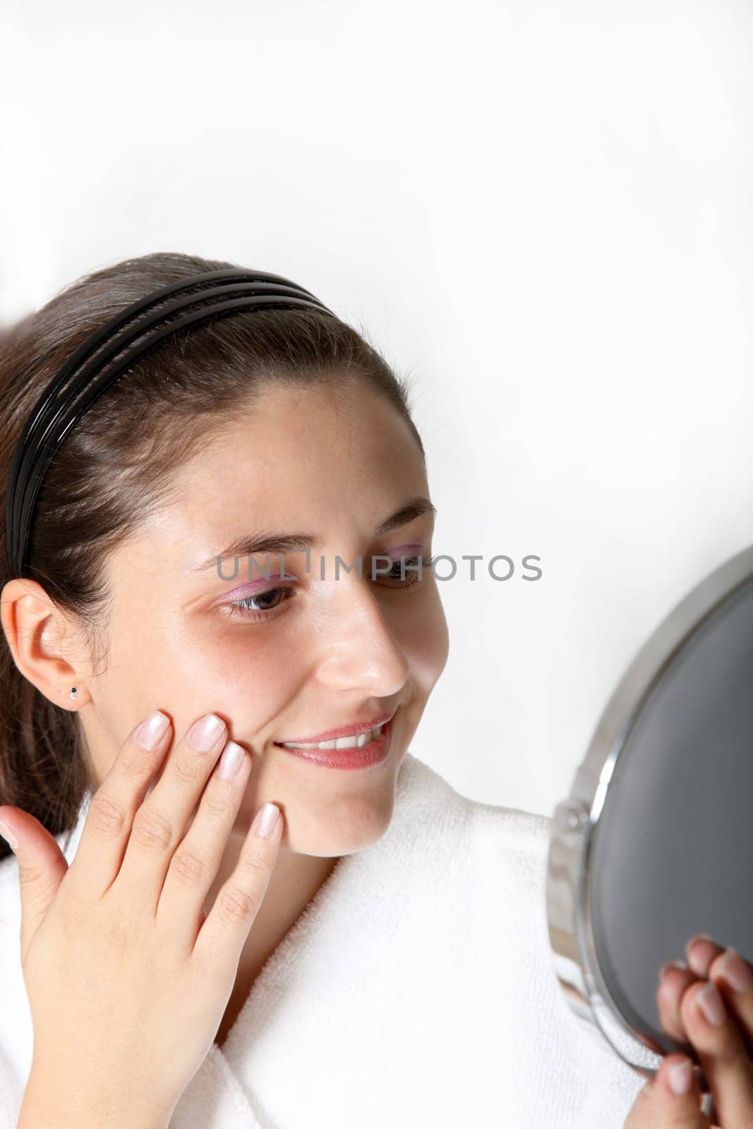 Woman in bathrobe looking in mirror