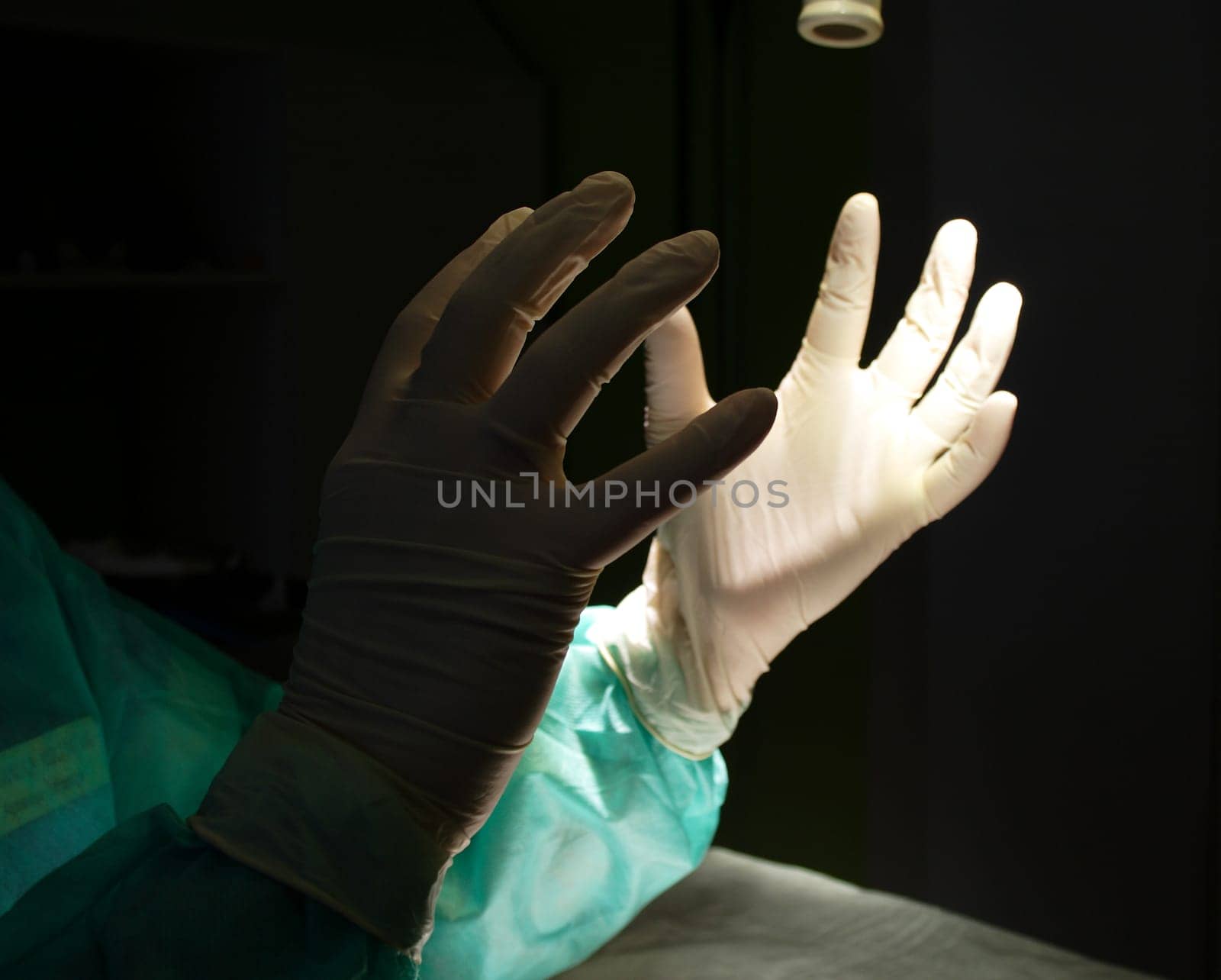 Surgeon holding up hands in protective gloves