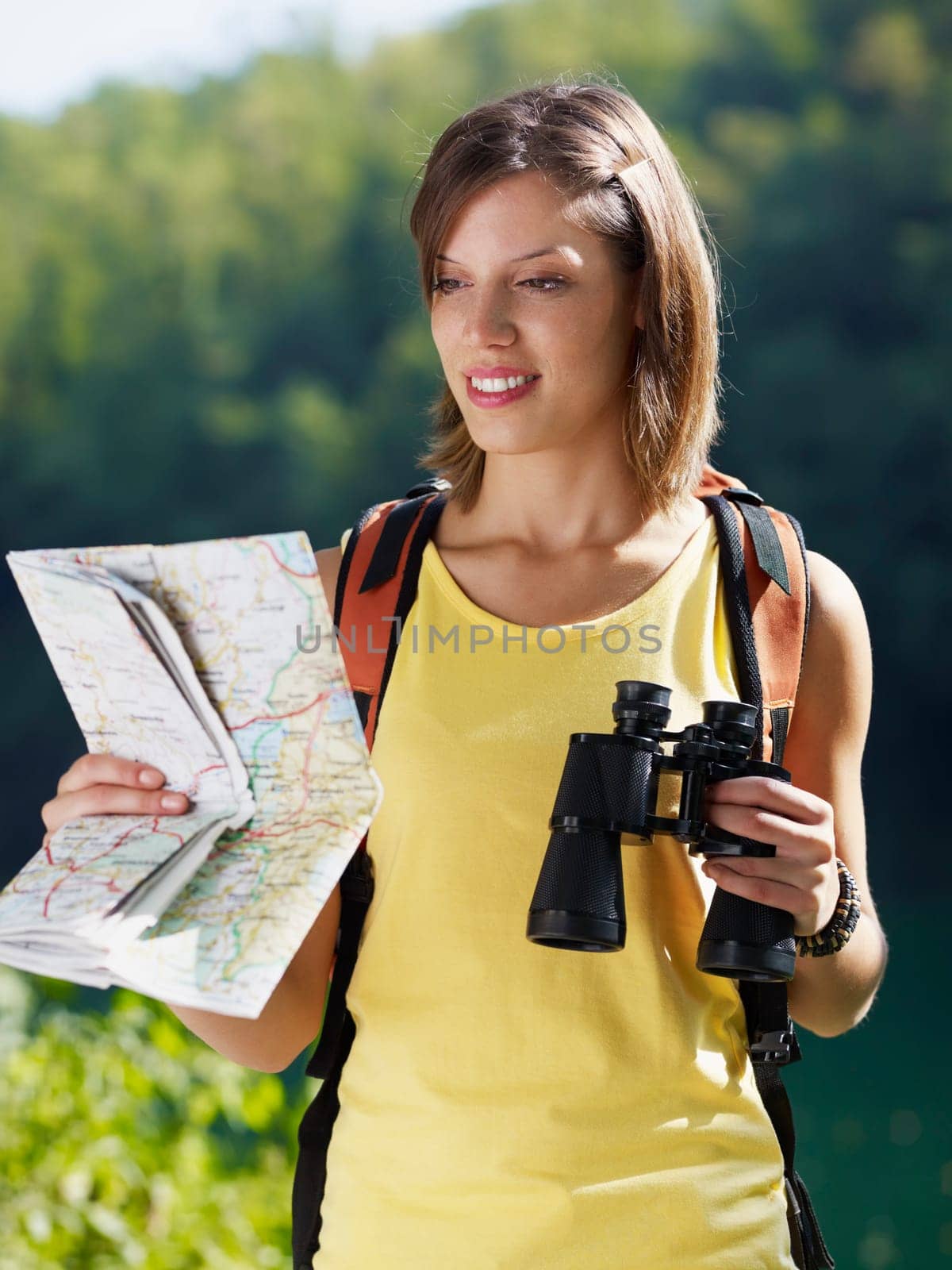 woman hiking with binoculars and map