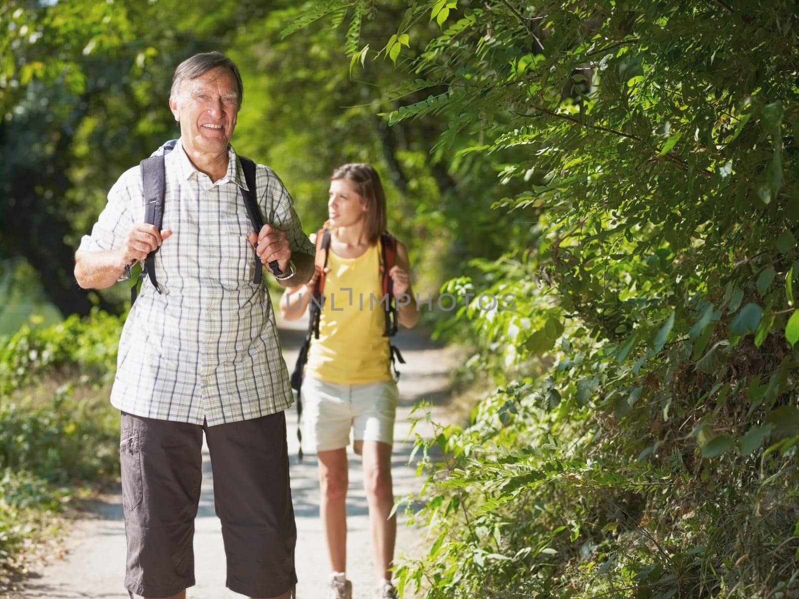 grandfather and grandaughter hiking in wood