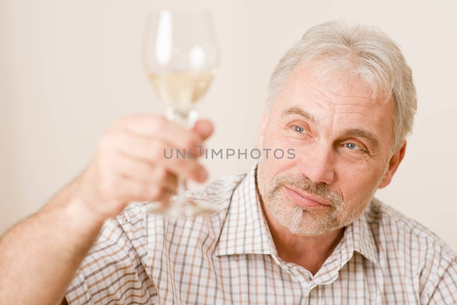 Senior mature man with glass of white wine