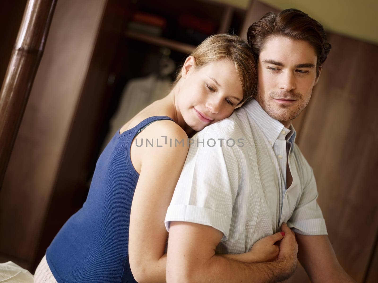 young heterosexual couple hugging on bed
