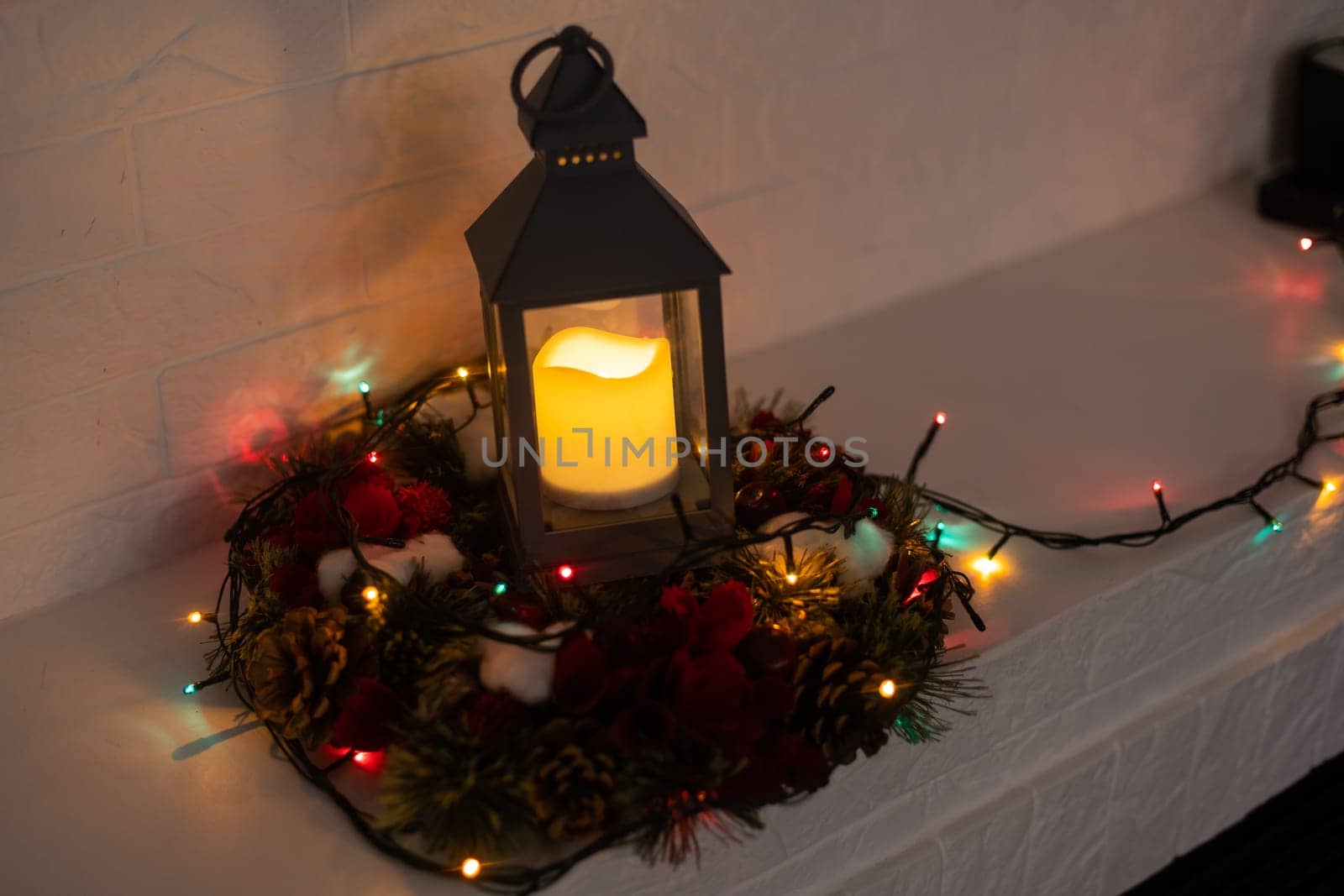 Christmas wreath handmade on a wooden background. Festive lights of garland. New Year's interior decoration