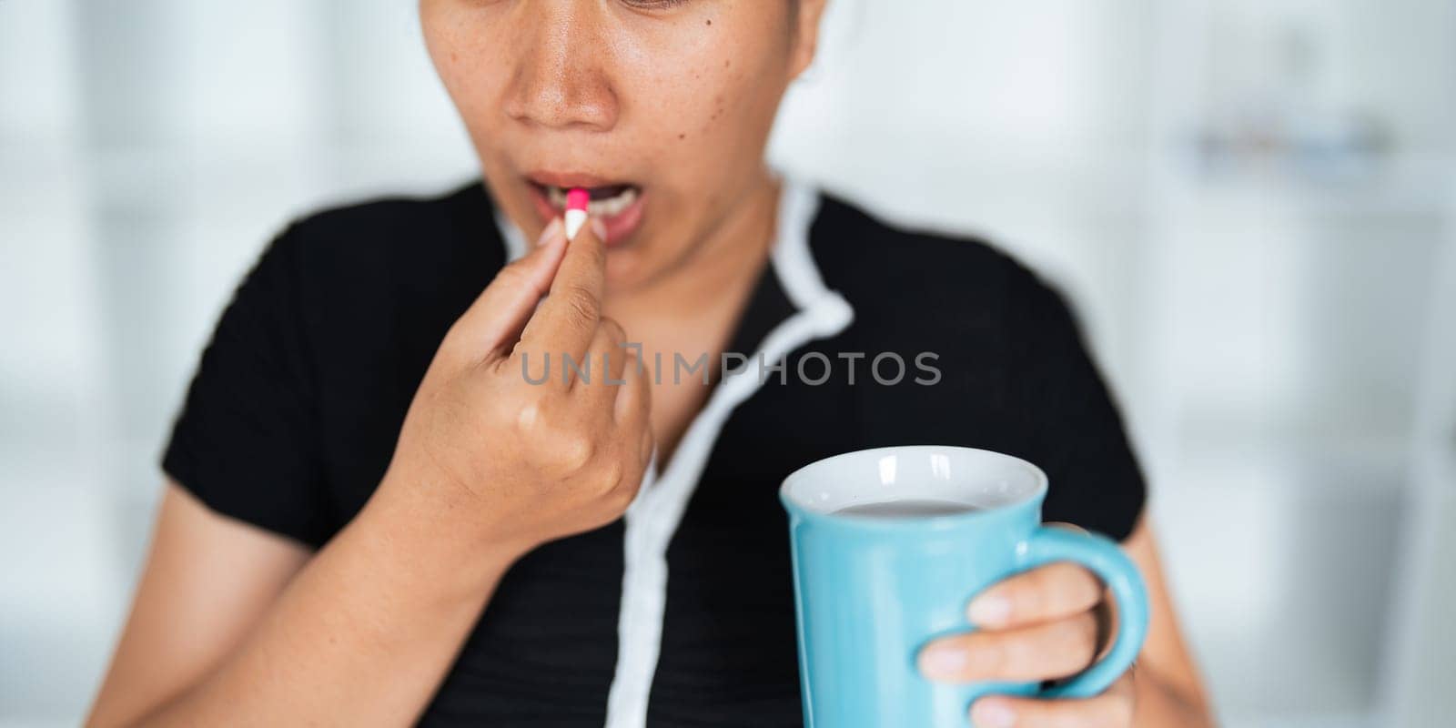 Close up woman holding pill in hand with water feeling sick. female going to take painkiller from headache, painkiller, healthcare, medicine, treatment, therapy, patient, disease illness concept by nateemee