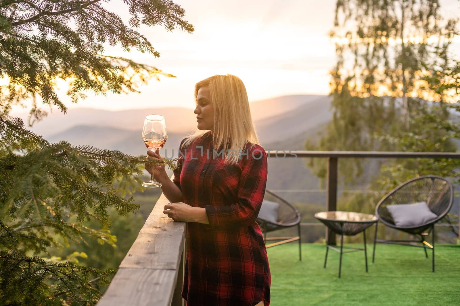 Young woman with glass of wine in peaceful mountains by Andelov13