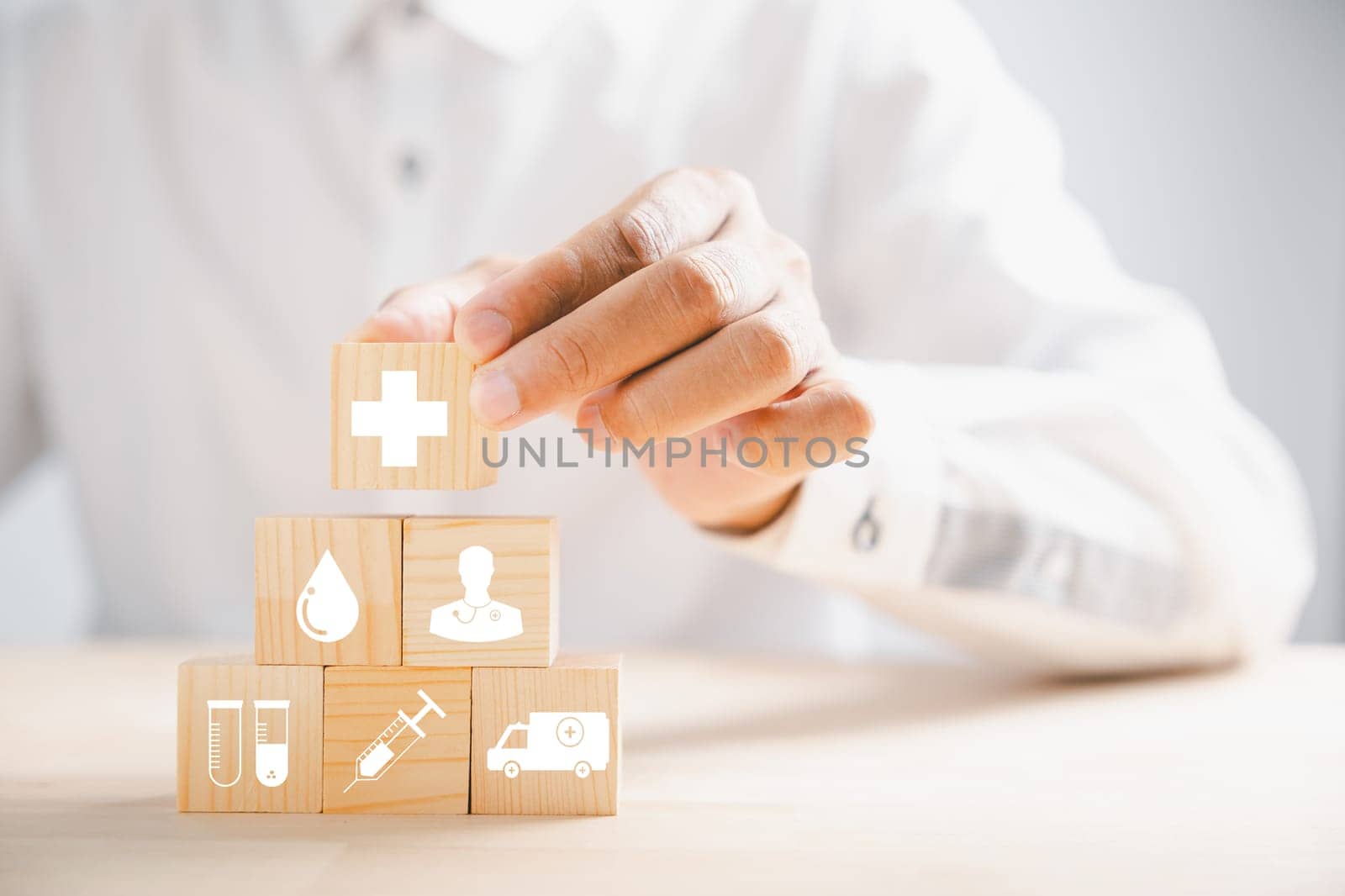 Grasped wooden block, featuring healthcare and medical icons. Portraying safety, health, and family well-being. Symbolic of pharmacy, heart care, and happiness. health care concept