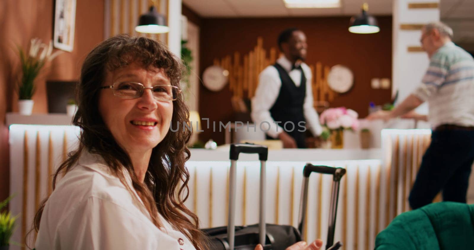 Old tourist relaxing in lounge area, using tablet to find online restaurants and landmarks. Woman guest travelling to all inclusive hotel, waiting to see room and start exploring the city.