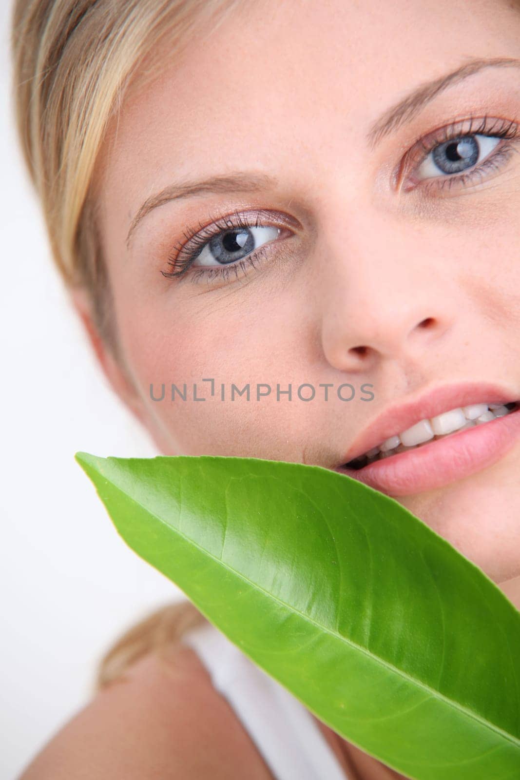 Closeup of beautiful woman holding green plant leaf