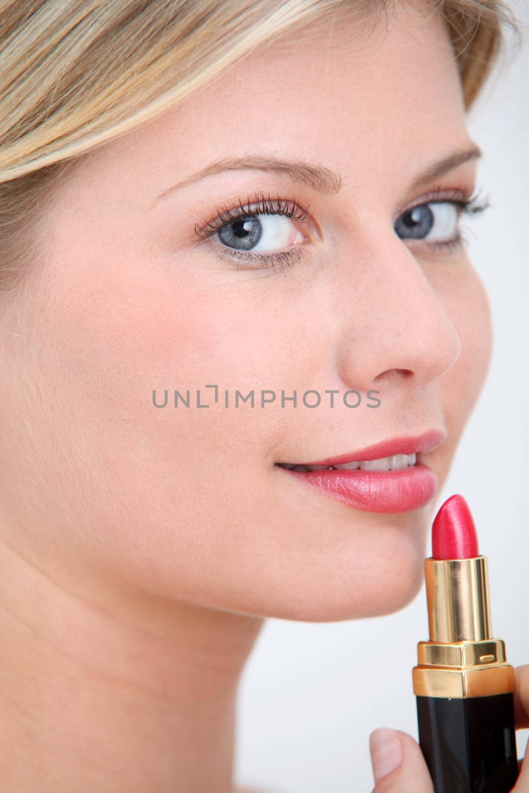 Blond woman putting makeup on