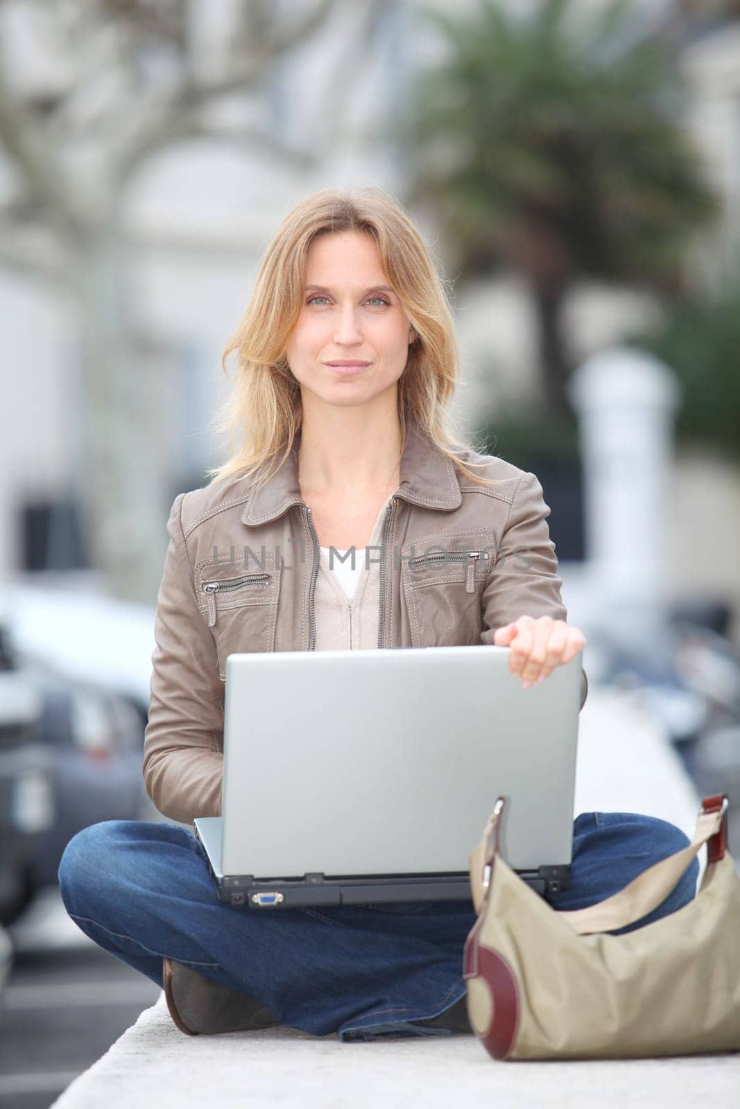Woman using laptop computer in town