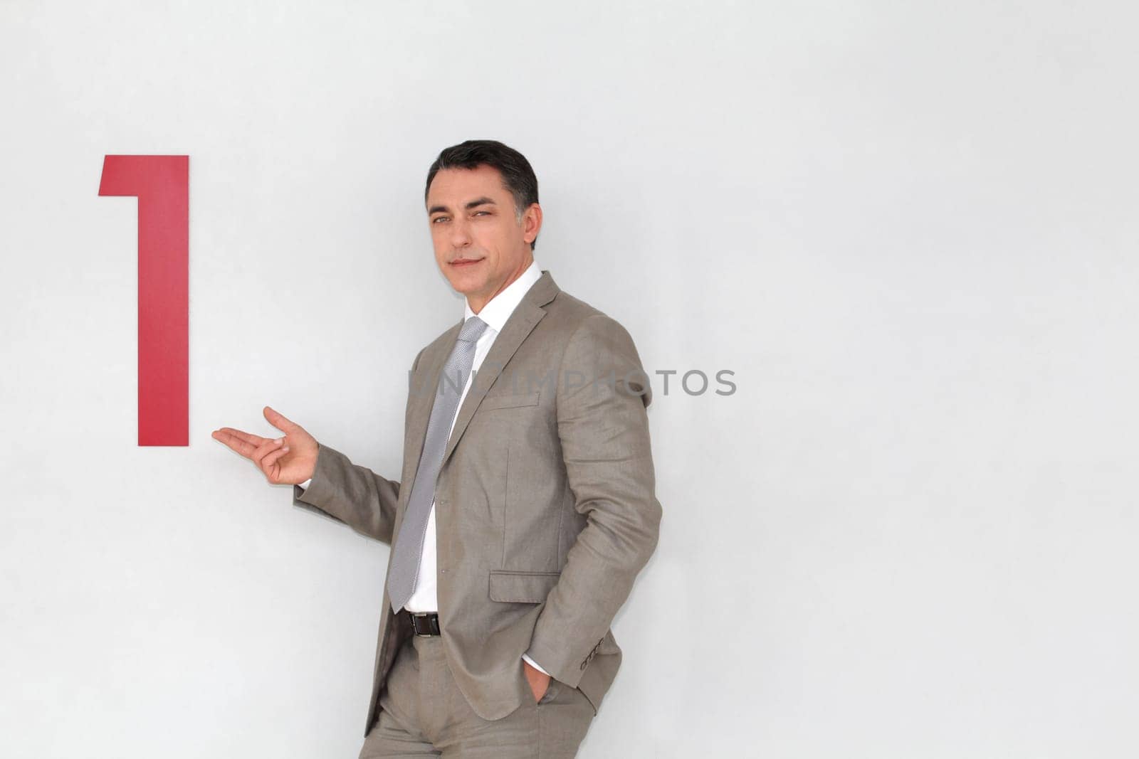 Successful businessman showing number one painted on wall