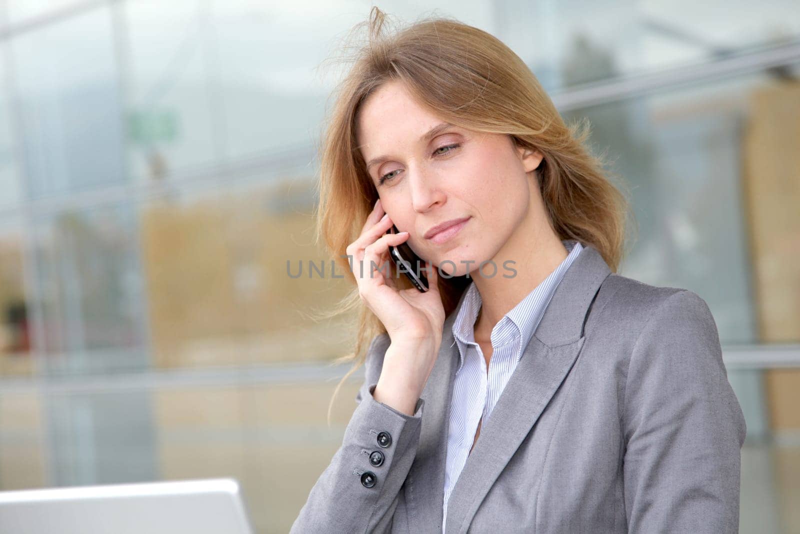 Businesswoman on the phone in front of modern building