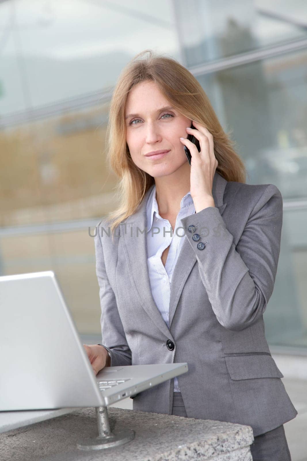 Businesswoman on the phone in front of modern building