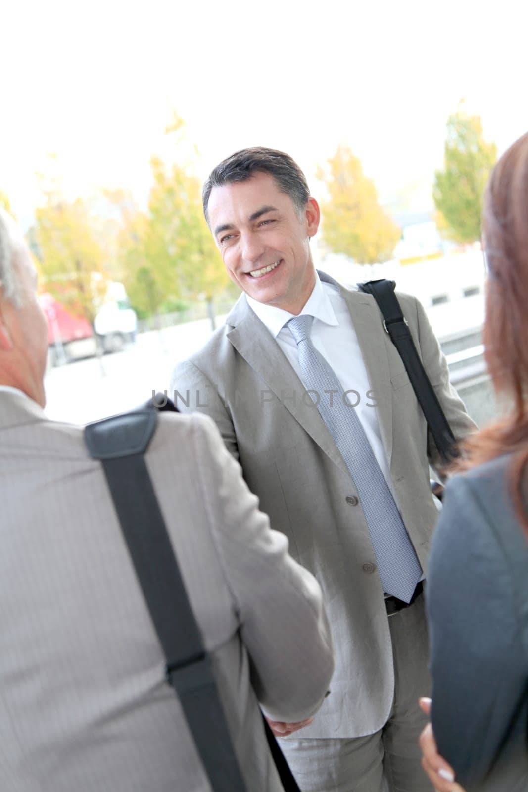 Businessmen shaking hands outside building