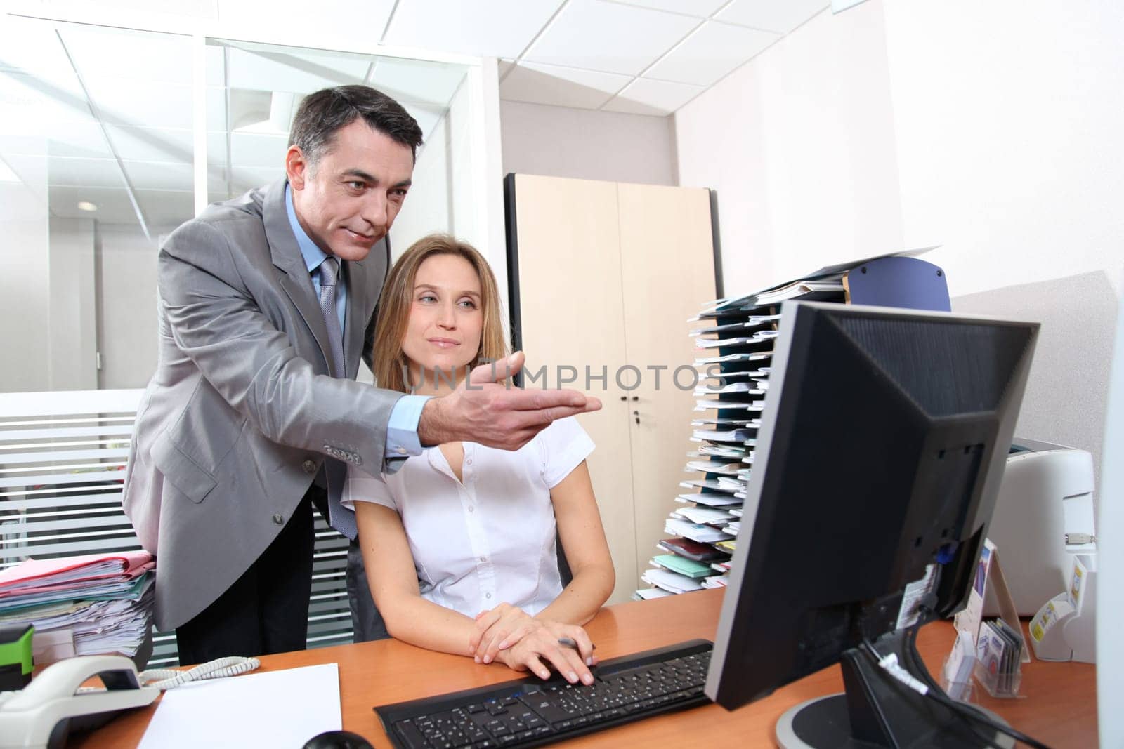 Manager and employee in front of computer in the office