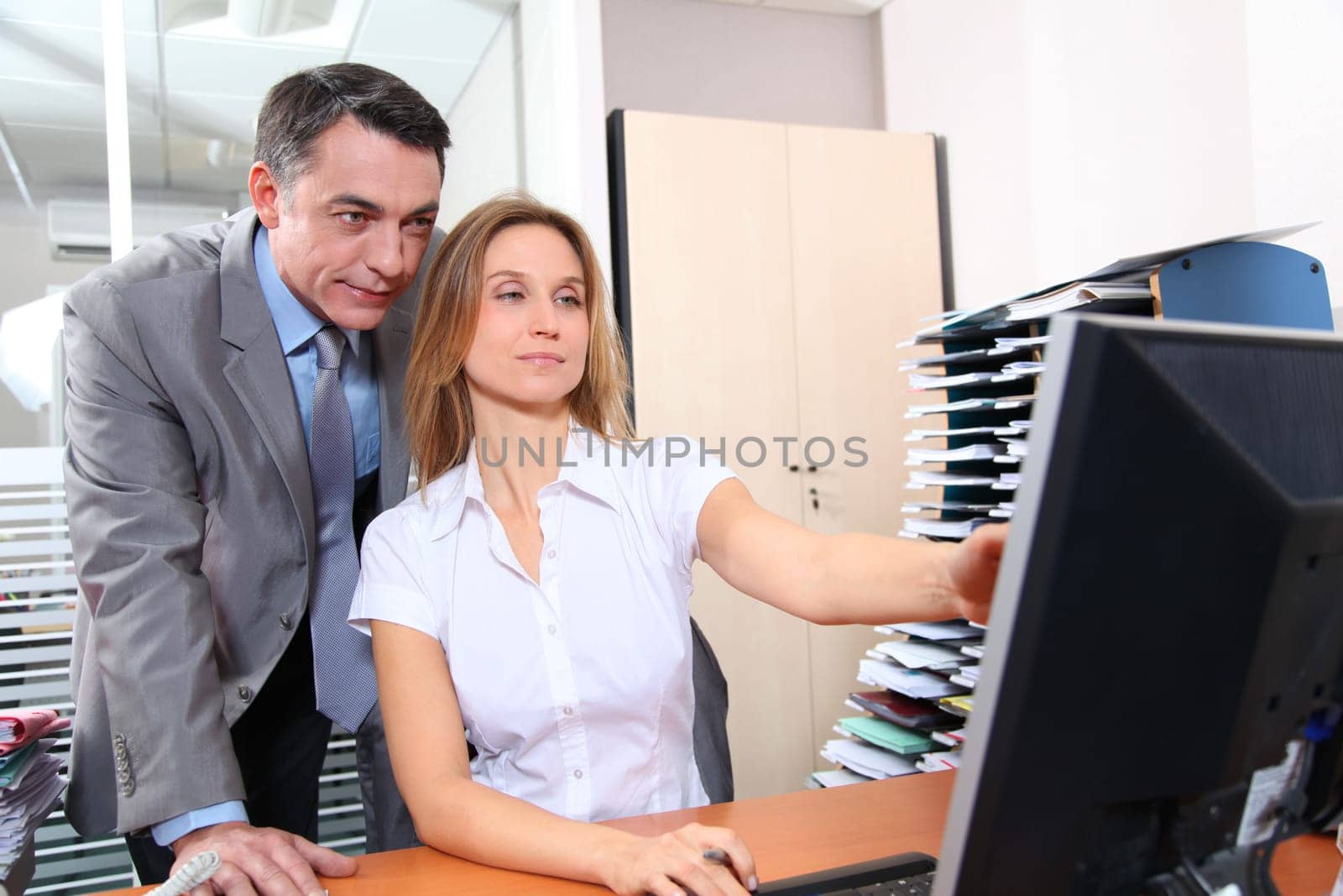 Manager and employee in front of computer in the office