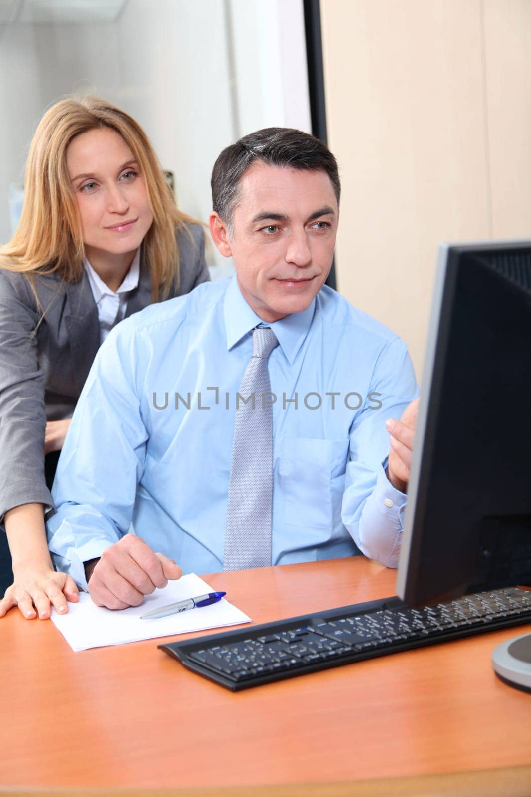 Manager and employee in front of computer in the office