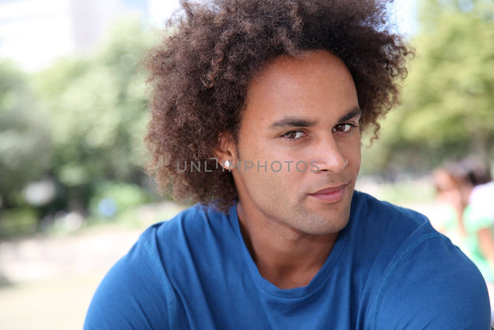 Closeup of young man sitting in a park