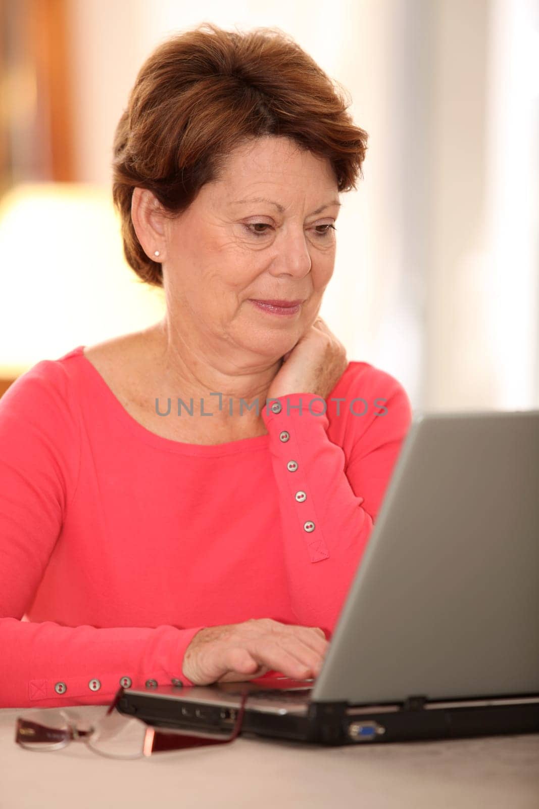 Closeup of senior woman at home with laptop computer