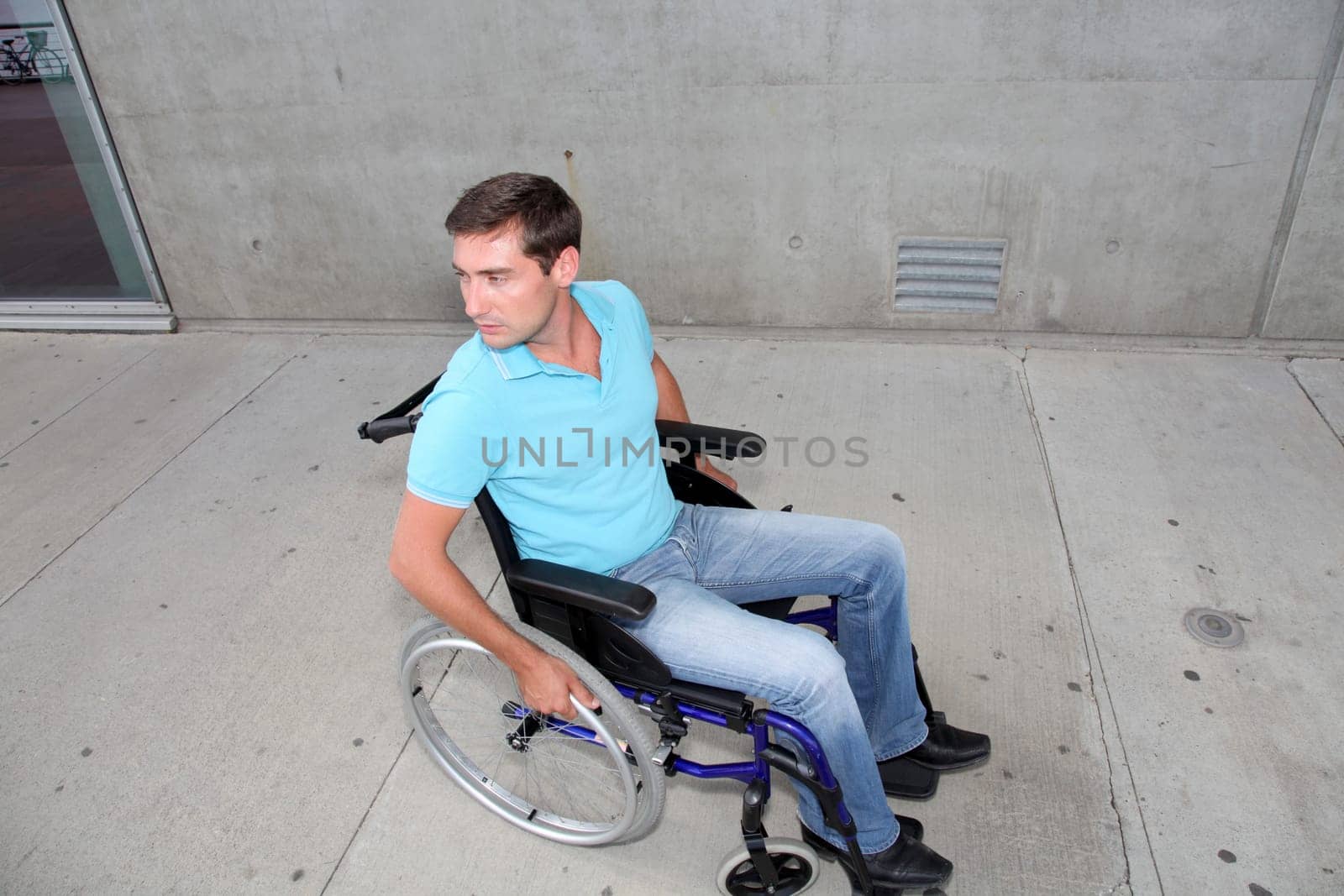 Young man using wheelchair in town