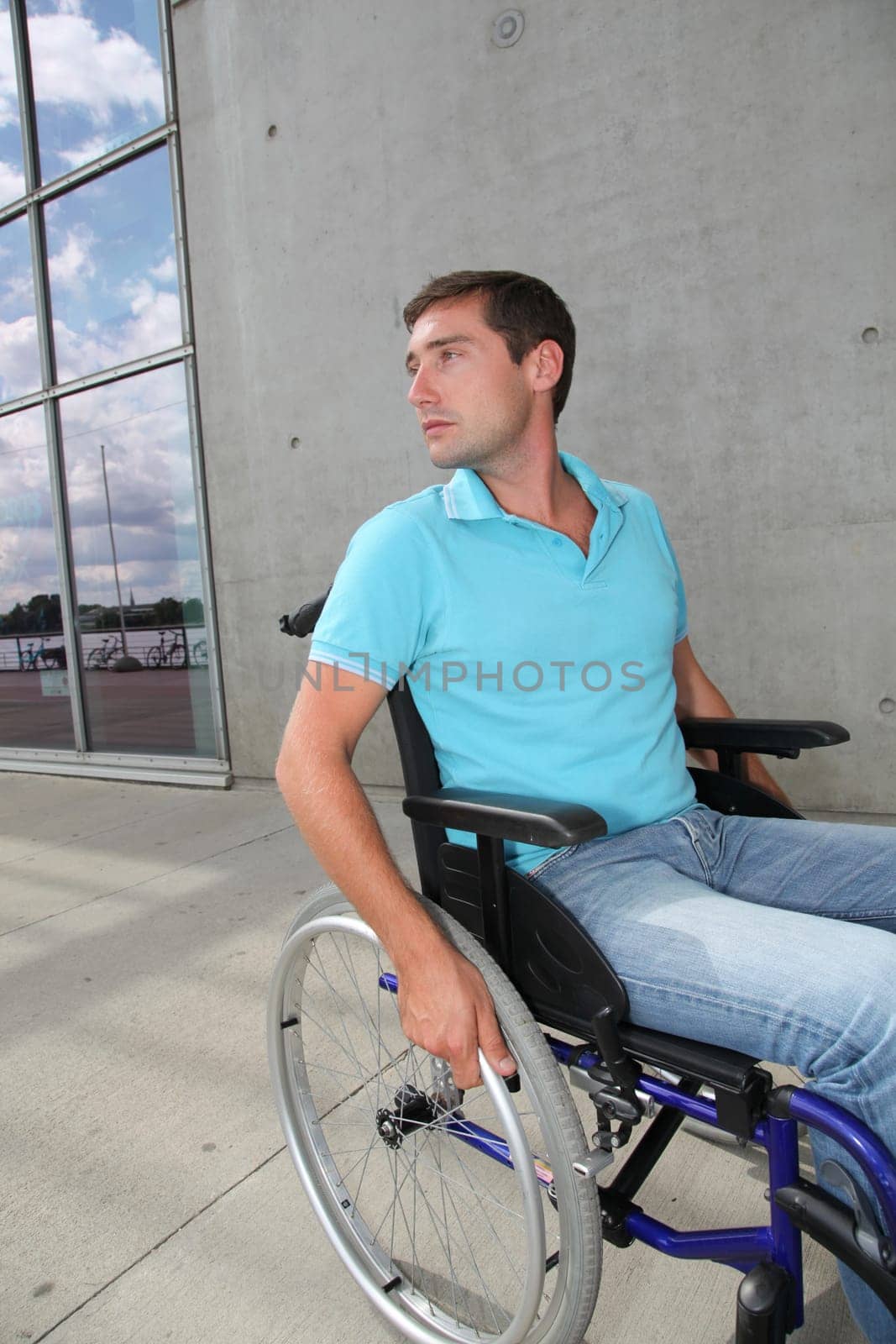 Young man using wheelchair in town