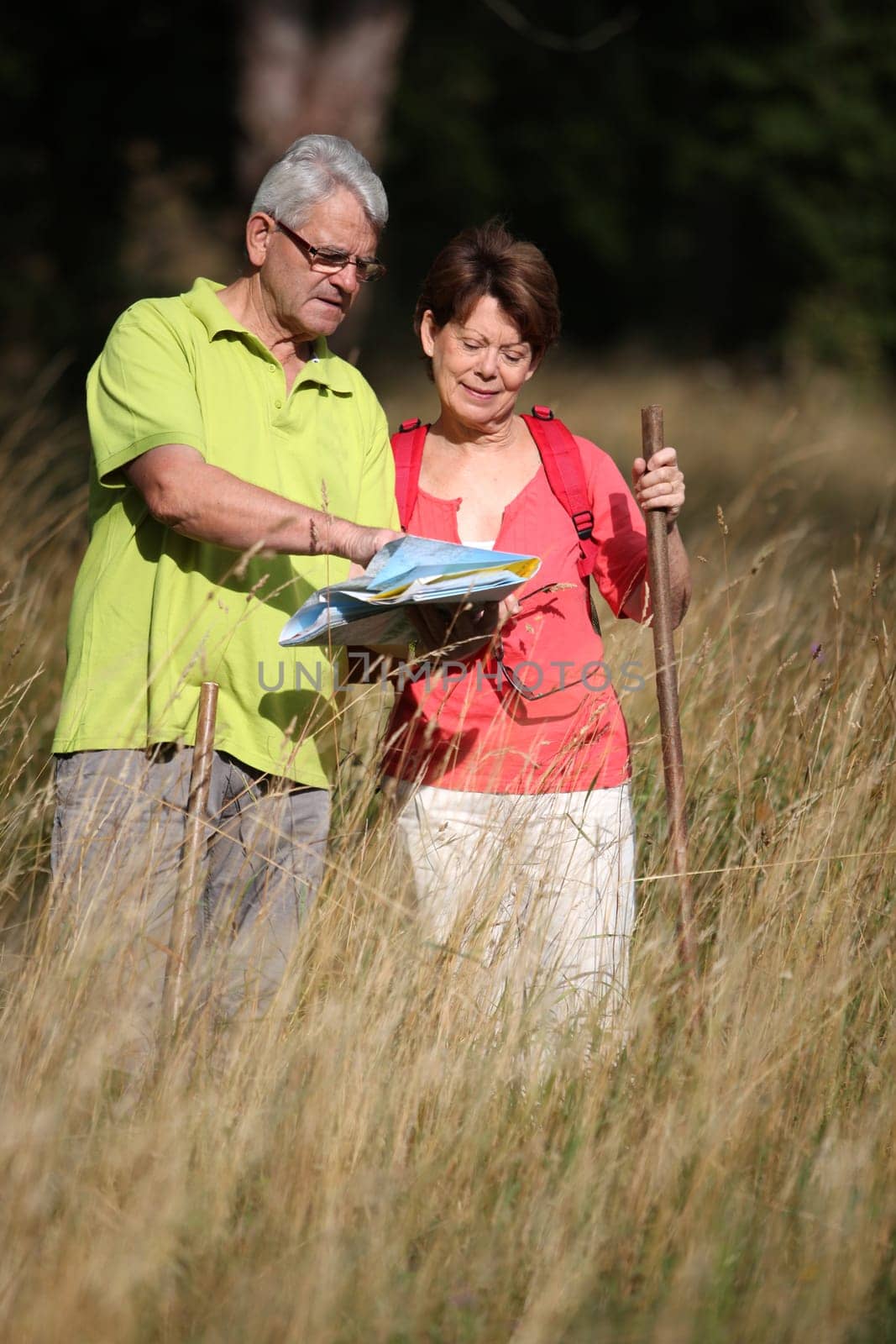 Senior couple rampling in countryside with map