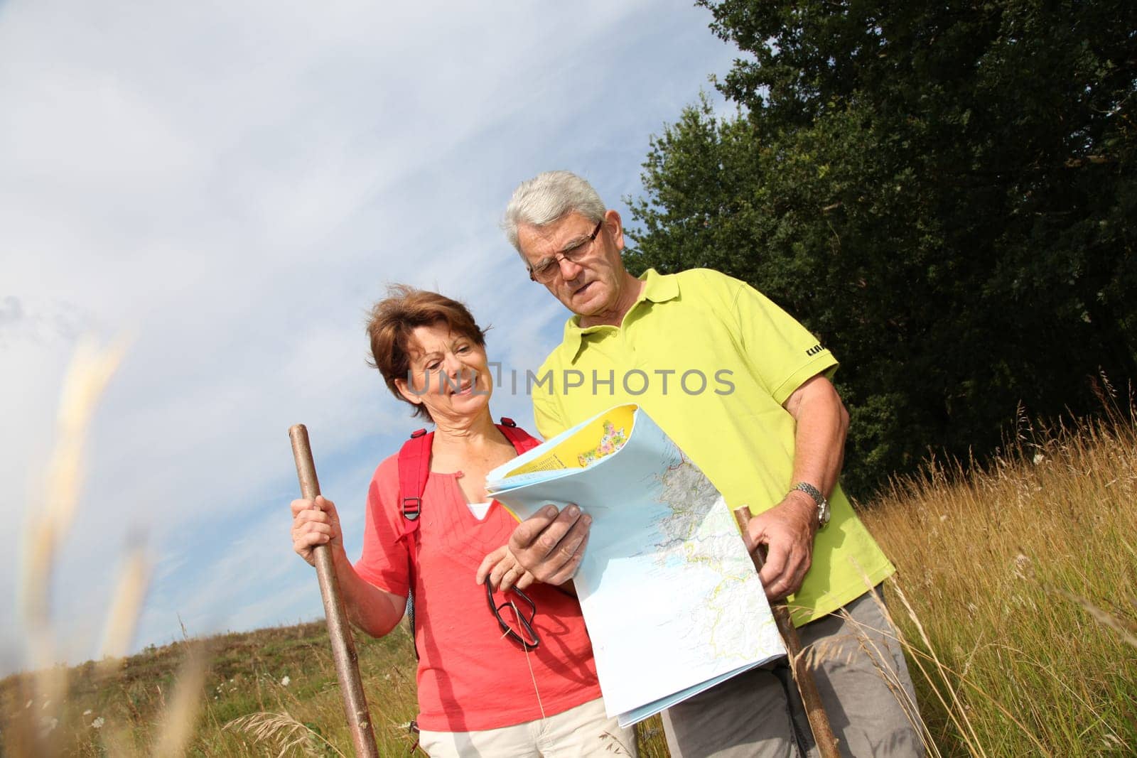 Senior couple rampling in countryside with map