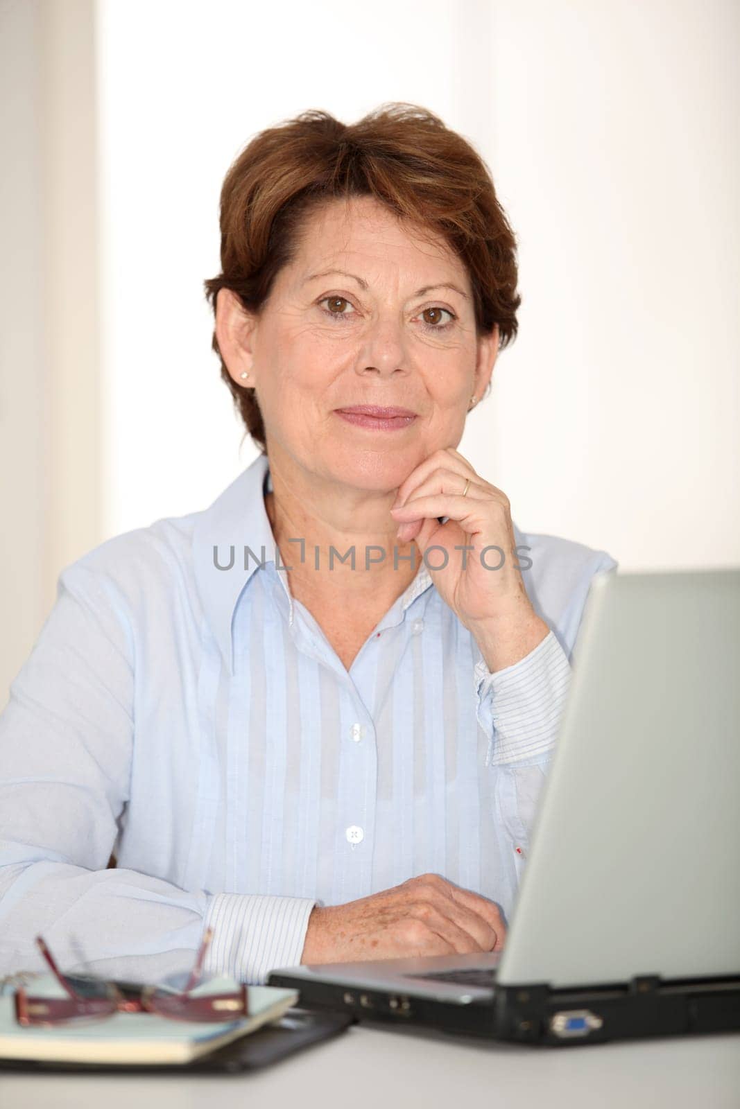 Closeup of senior woman working in office with laptop computer