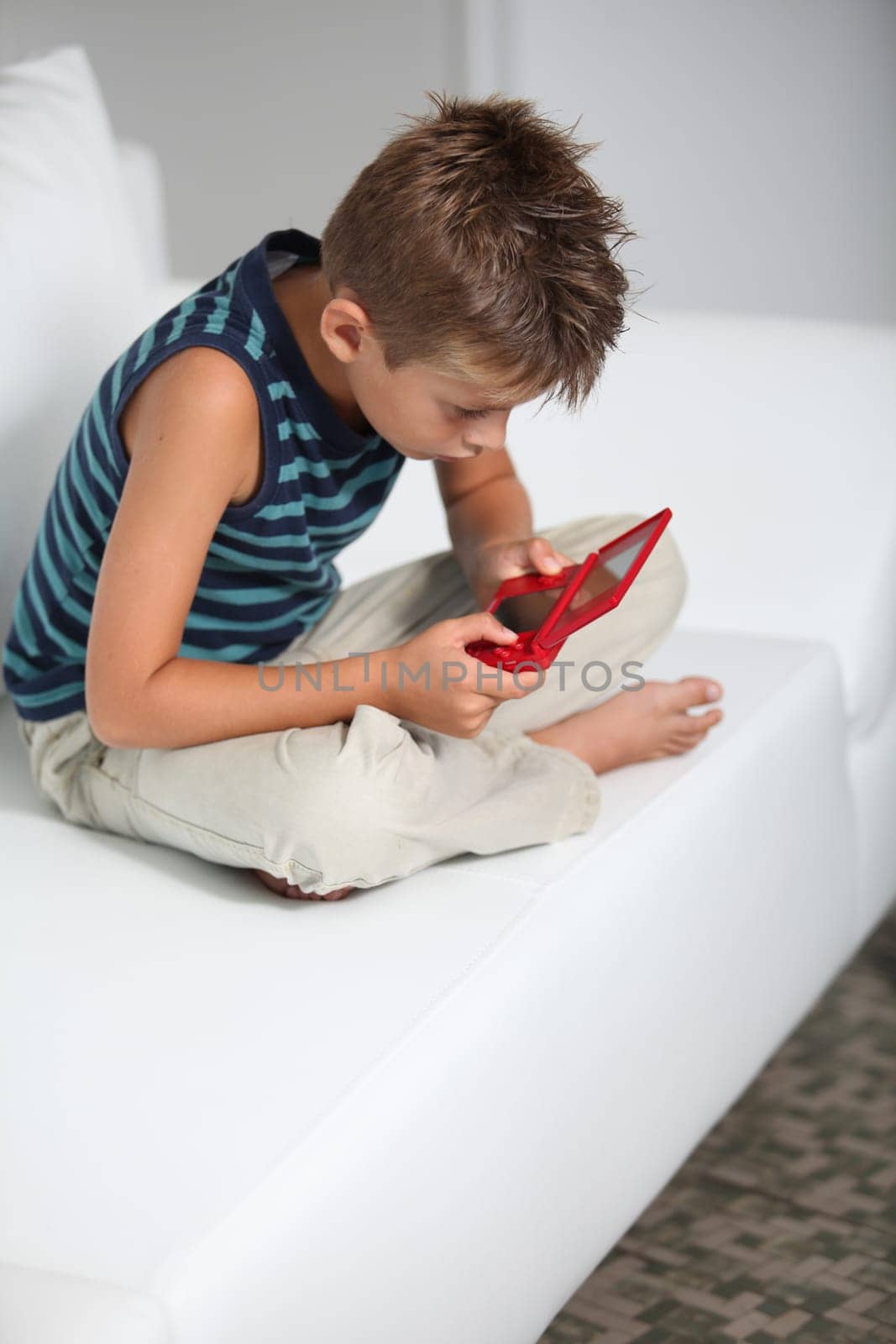 Little boy playing video games on sofa