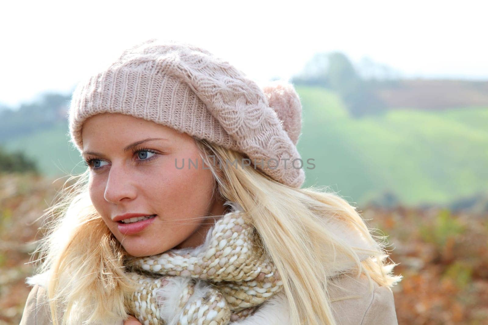 Blond woman wearing wool cap in autumn