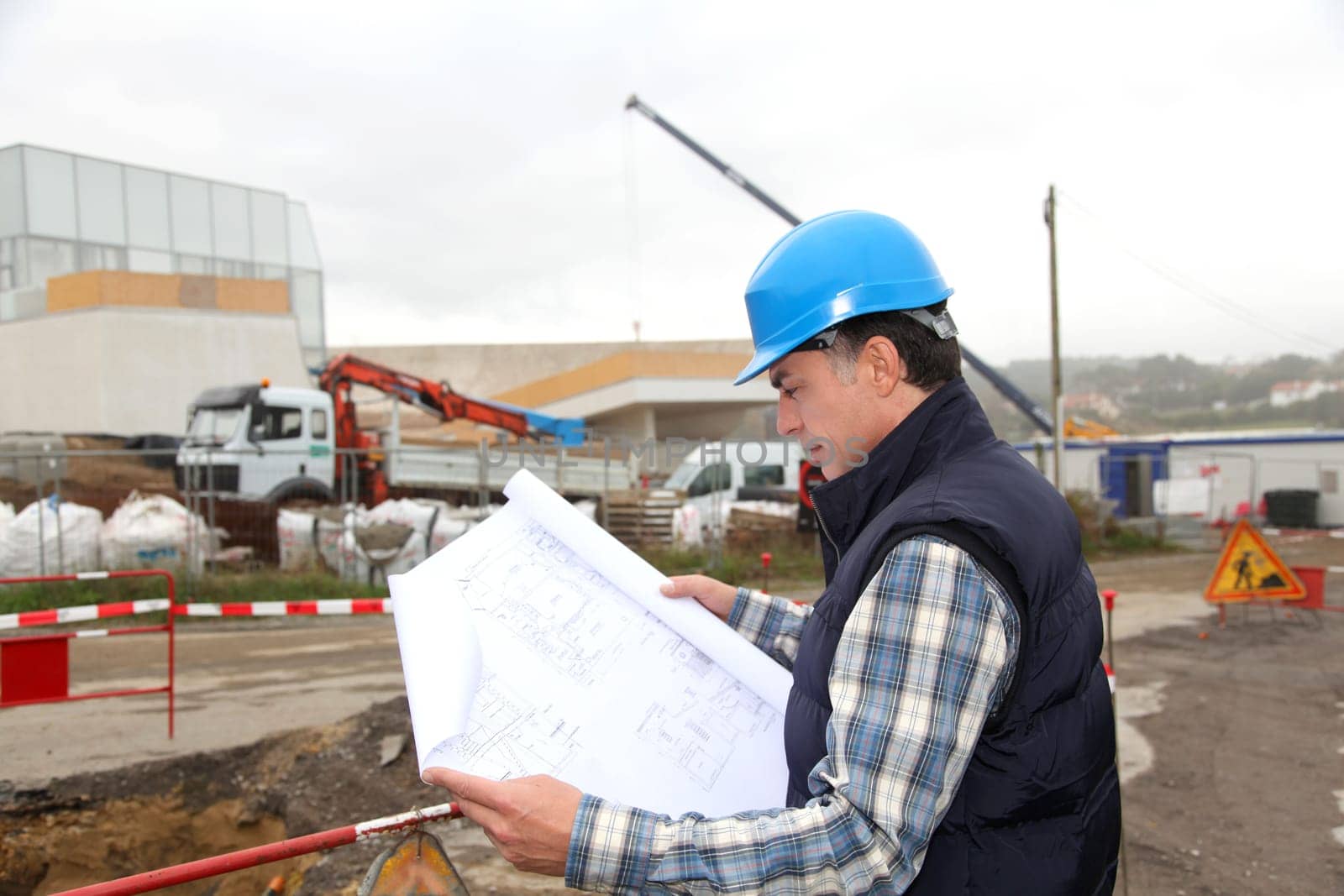 Engineer on construction site with building plan