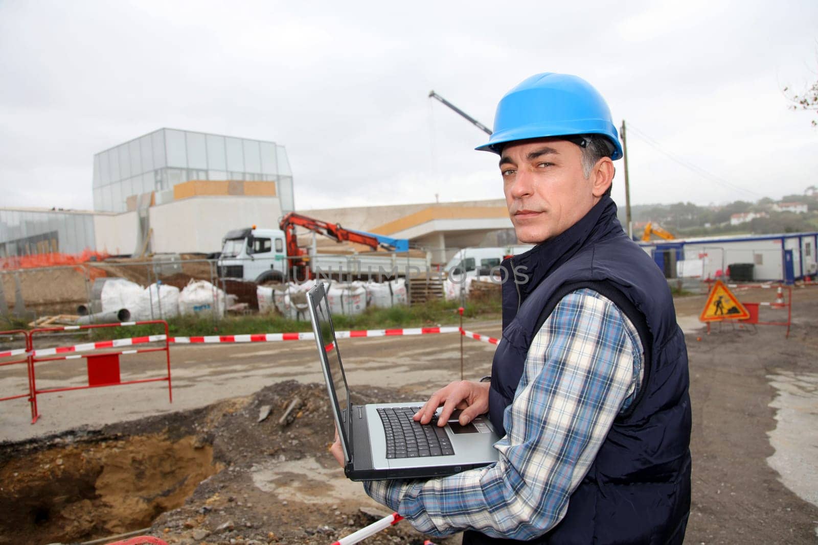 Engineer on construction site with laptop computer