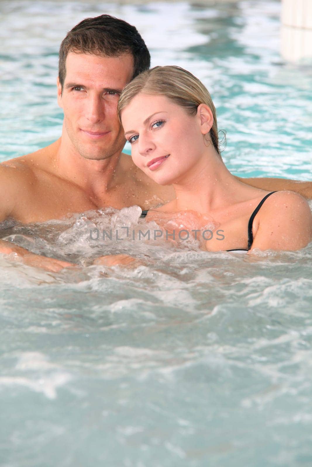 Couple bathing in jacuzzi of spa center