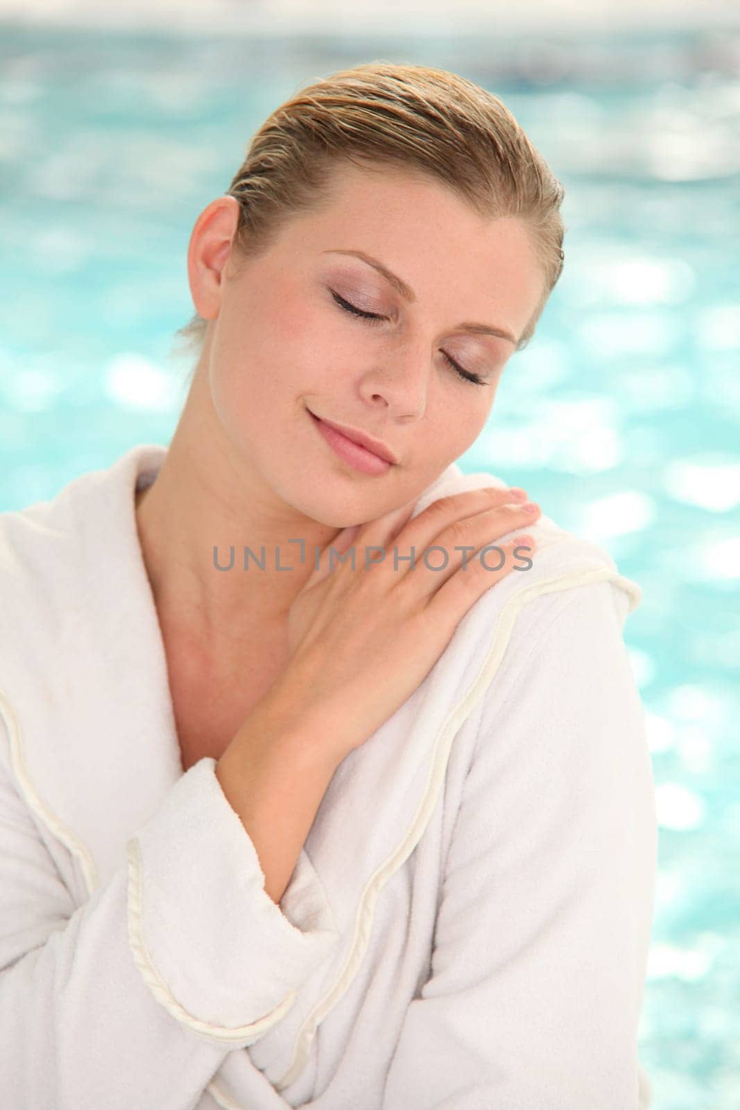 Beautiful woman with bathrobe standing by spa pool