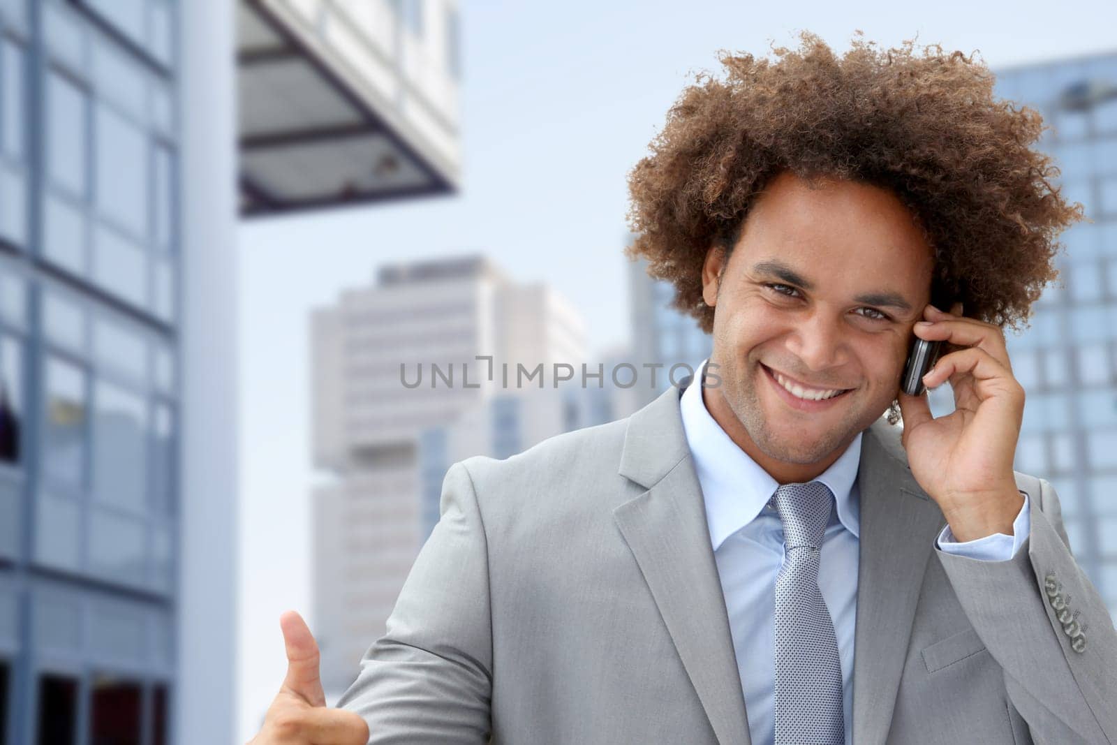 Businessman on the phone in front of modern building