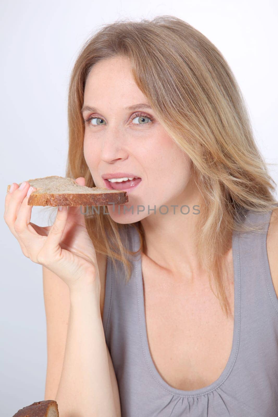 Closeup of beautiful woman eating slice of bread