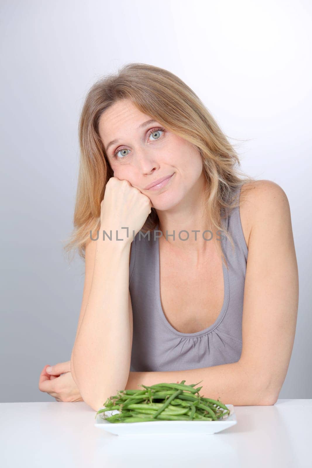 Unhappy woman in front of green beans