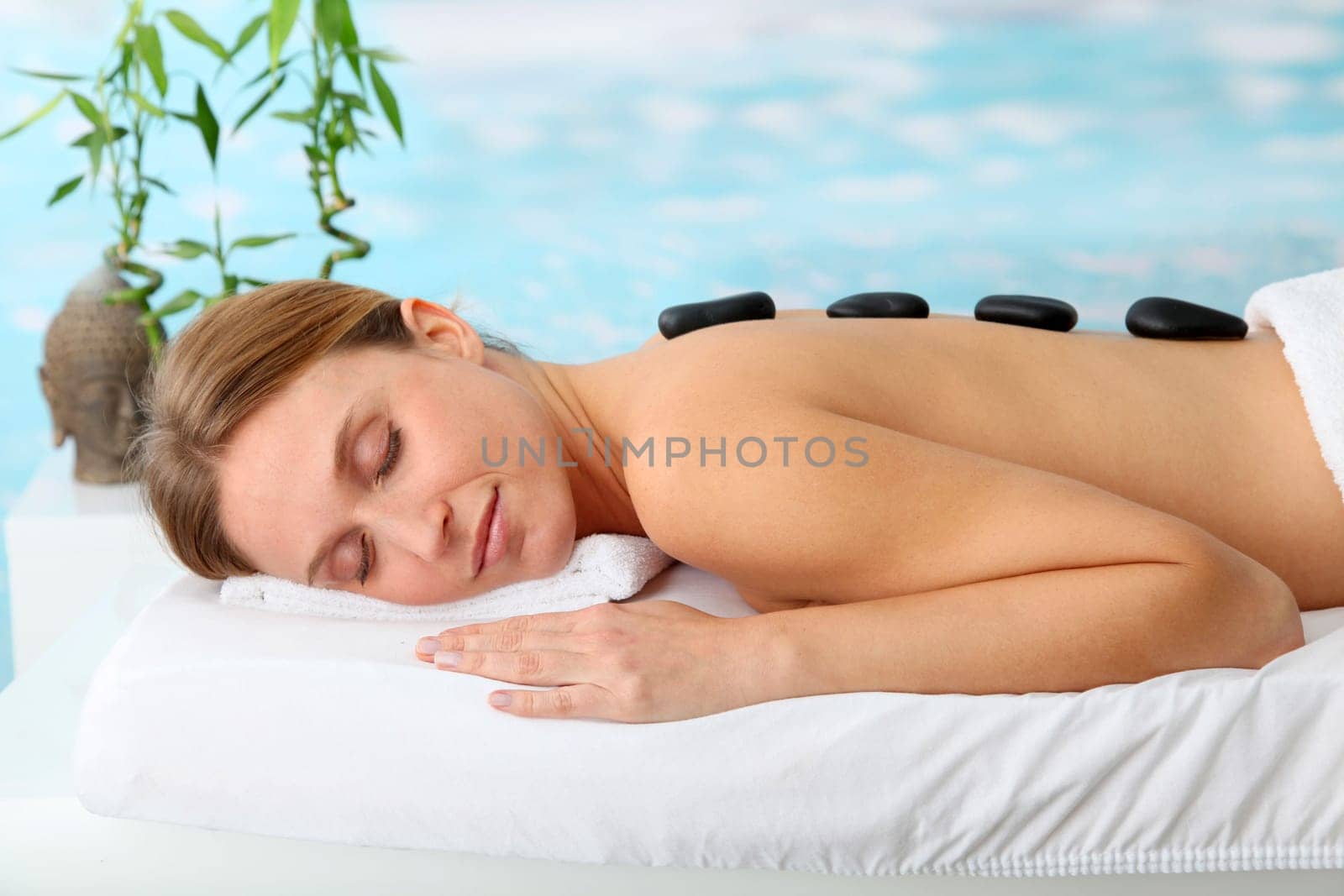 Beautiful woman with hot stones on her back
