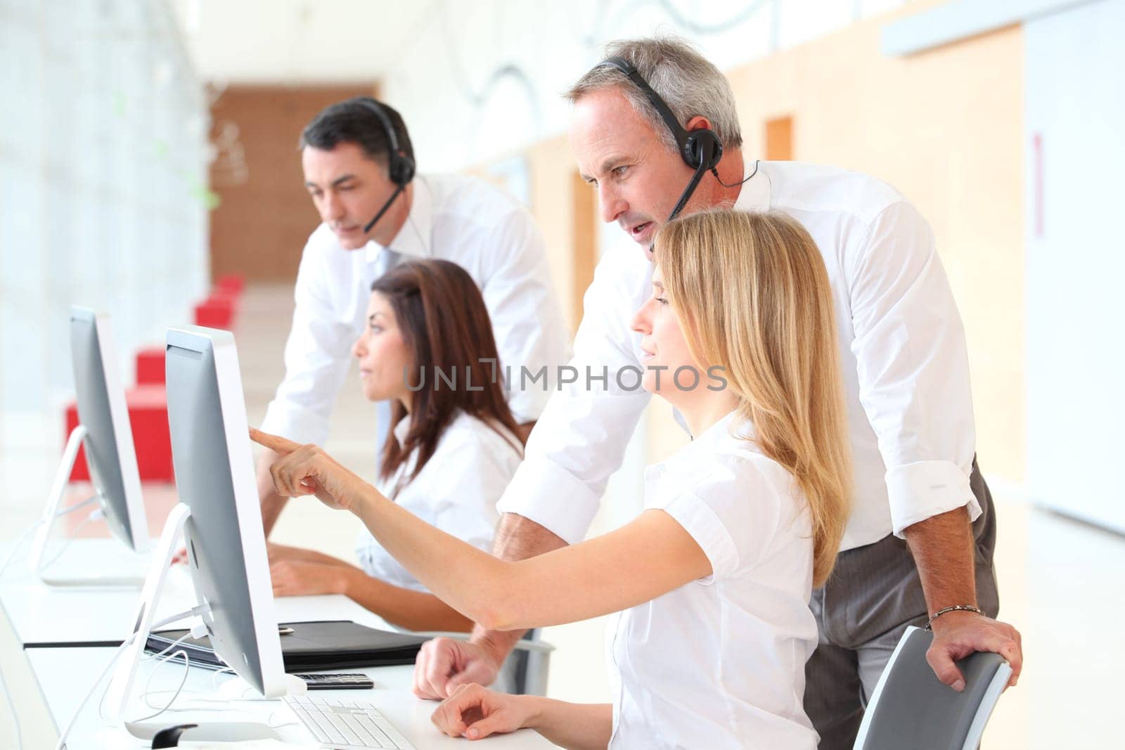 Business people working in front of computer with headphones