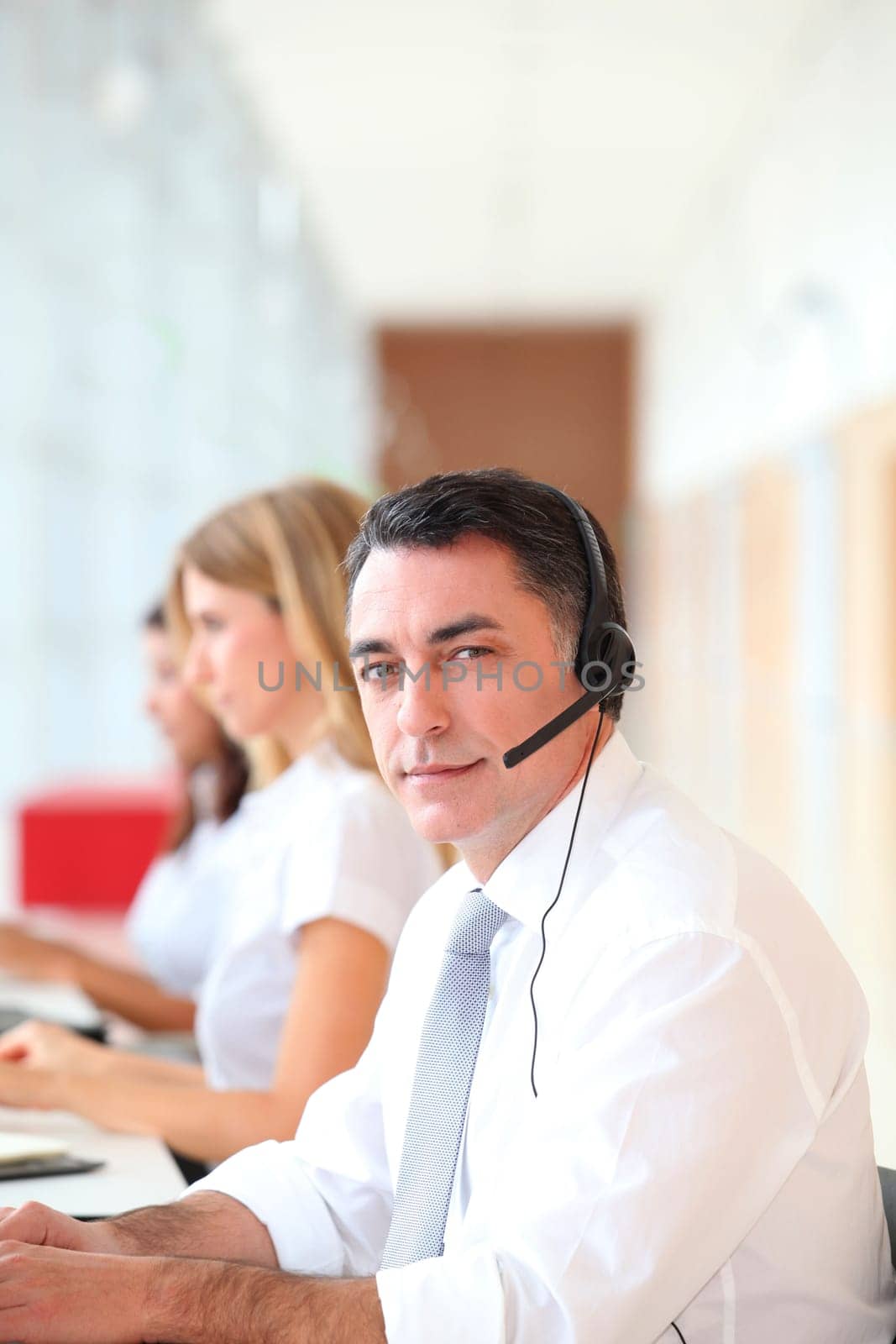 Business people working in front of computer with headphones
