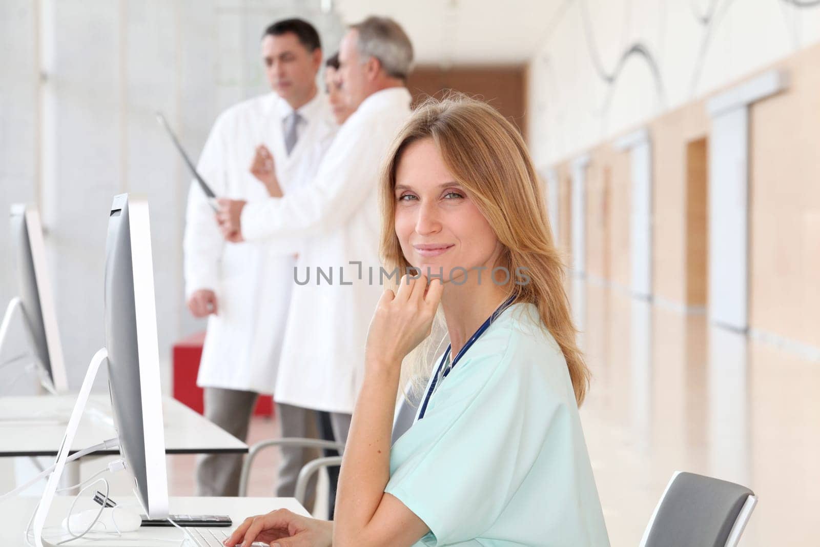 Portrait of beautiful nurse in front of medical people